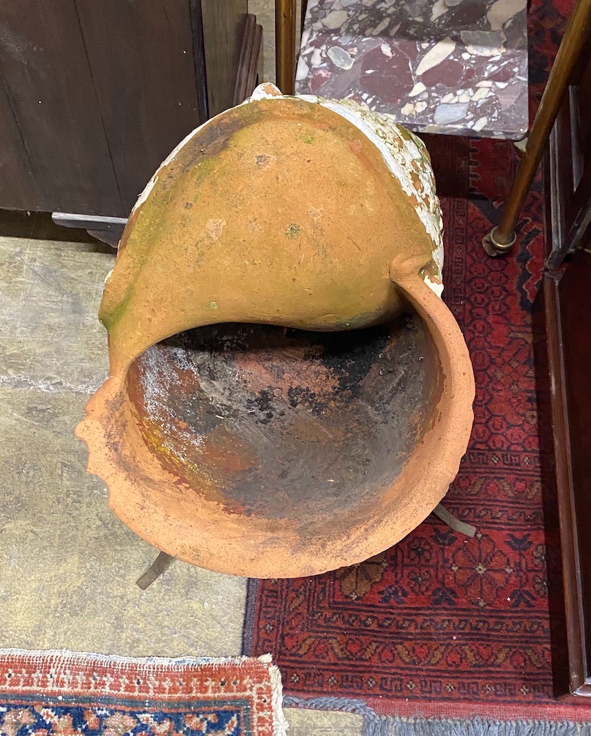 An unusual terracotta garden planter on wrought iron stand modelled as a conch shell, height 56cm